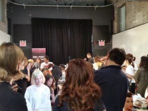 Models get prepped in hair and makeup backstage. 