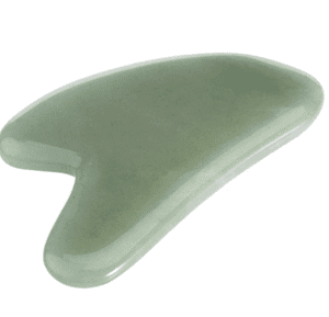 Photo of a Gua Sha, which is a piece of smooth green stone with an indent in the stone to be used along the cheekbone and jawline