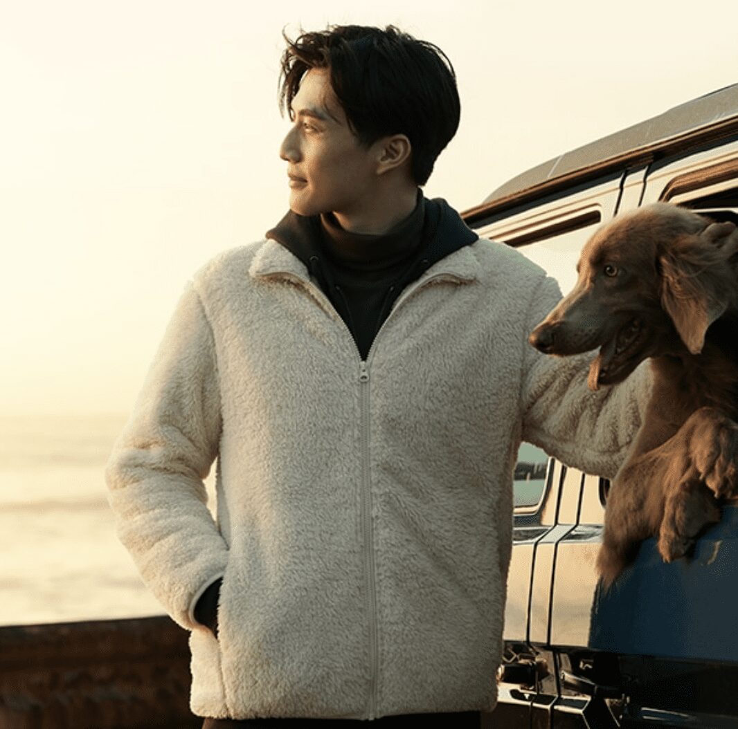 Photo of man wearing UNIQLO jacket with a golden retriever in a car