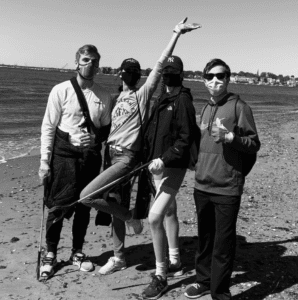Photo of Lindsey Coffey working alongside friends to pick up trash along a beach