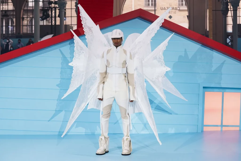 Abloh's angel in an all-white ensemble in front of the on-set house. Photo: Francois Durand/Getty Images.