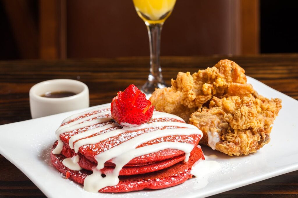 a plate of red velvet pancakes and fried chicken.