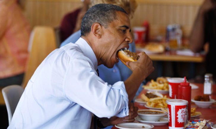 Barack Obama eating a chili dog at a restaurant