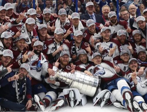 Avalanche team staff and players gather around for Stanley Cup photo after winning the Finals. Photo via Sporting News