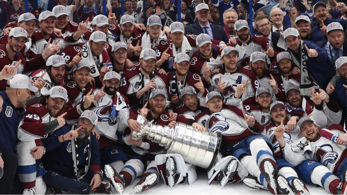 Avalanche team staff and players gather around for Stanley Cup photo after winning the Finals. Photo via Sporting News