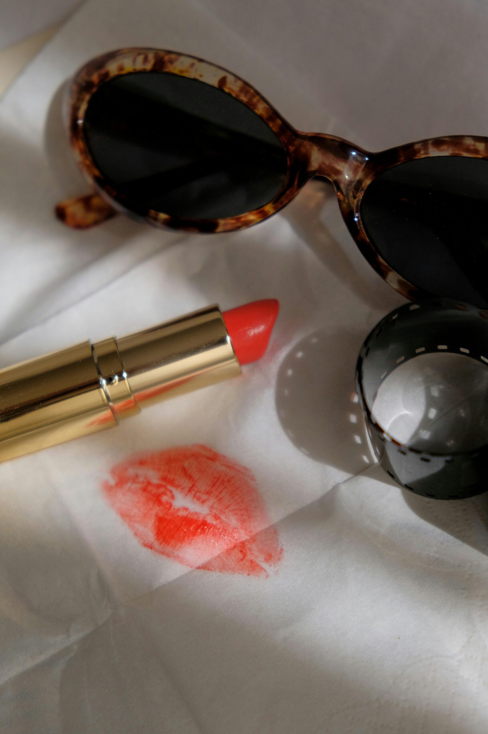 lipstick kiss on tissue and sunglasses
