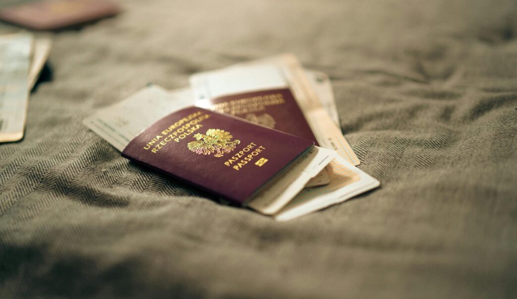 A close-up of multiple passports stacked together, symbolizing immigrant identity and global heritage.