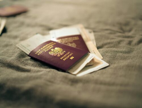 A close-up of multiple passports stacked together, symbolizing immigrant identity and global heritage.