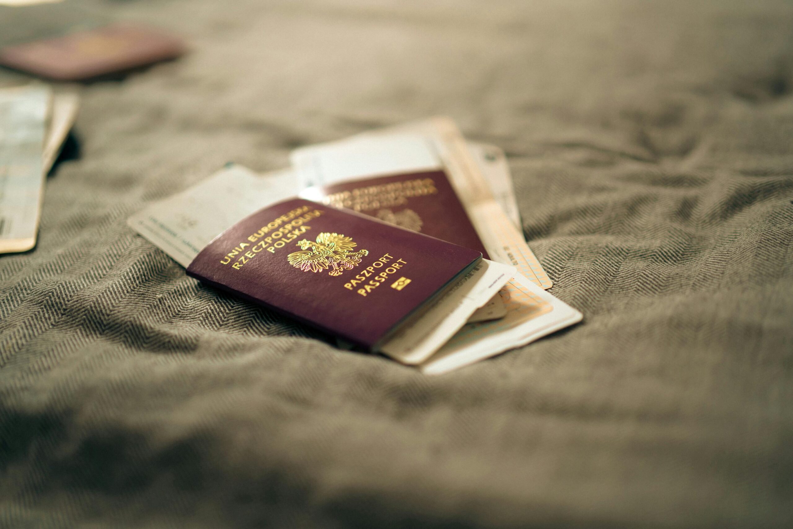 A close-up of multiple passports stacked together, symbolizing immigrant identity and global heritage.